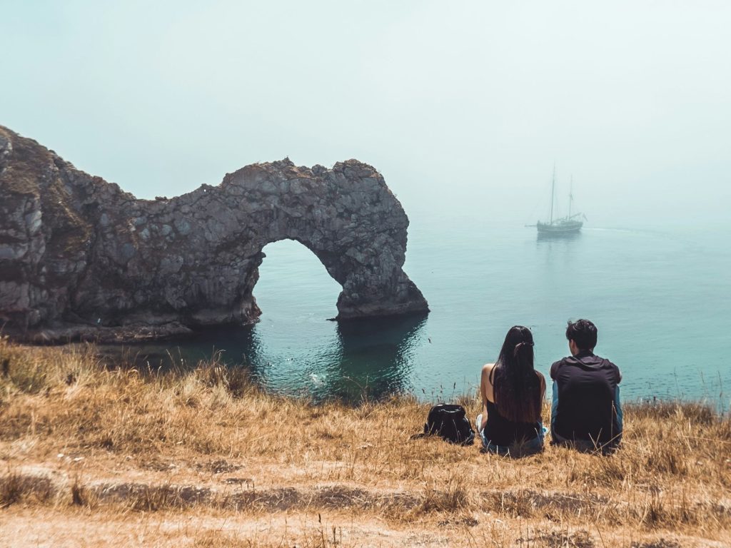 Couple on holiday in Dorset sitting by the Coast