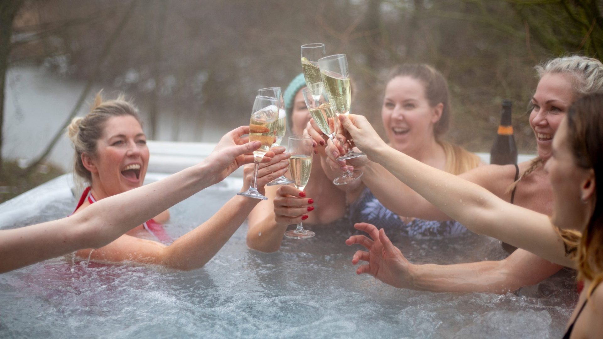 A group of friends raising a toast in a Dorset holiday cottage with a hot tub