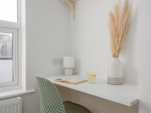 Close-up of desk with book and plant at Beachway House holiday cottage