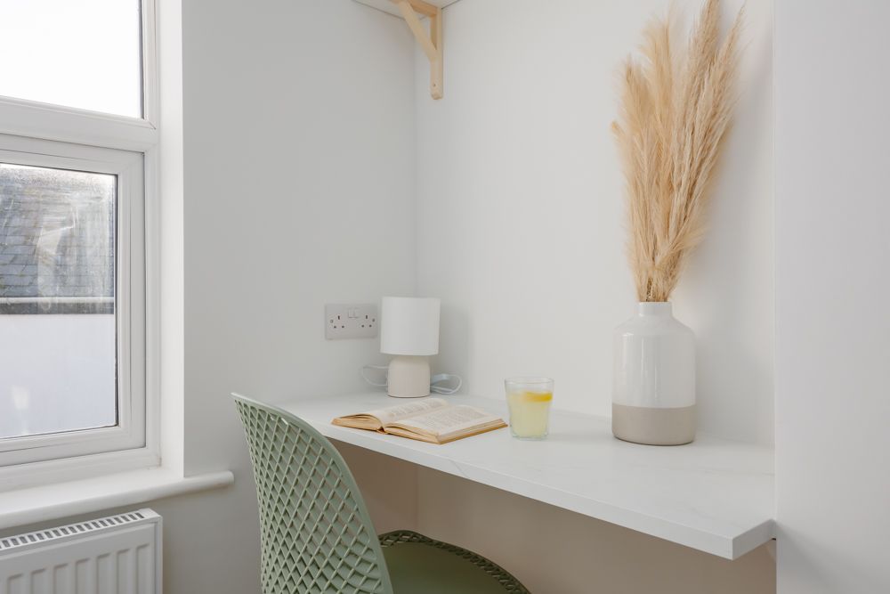Close-up of desk with book and plant at Beachway House holiday cottage