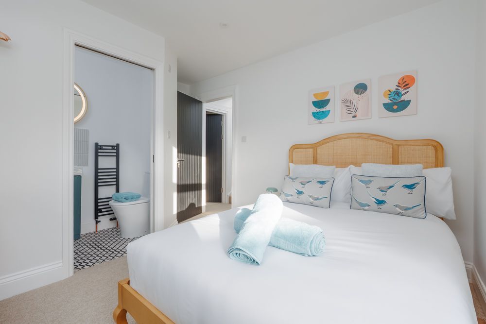 Coastal-themed bedroom with en suite bathroom at Beachway House holiday cottage