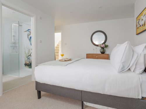 Bedroom with en suite bathroom and crane design on shower screen
