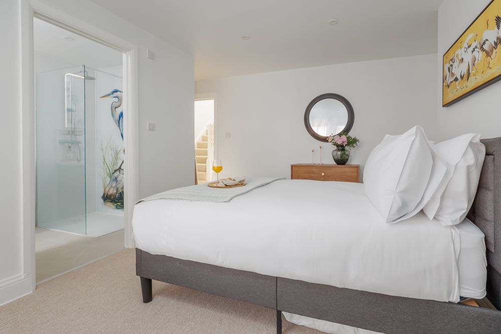 Bedroom with en suite bathroom and crane design on shower screen
