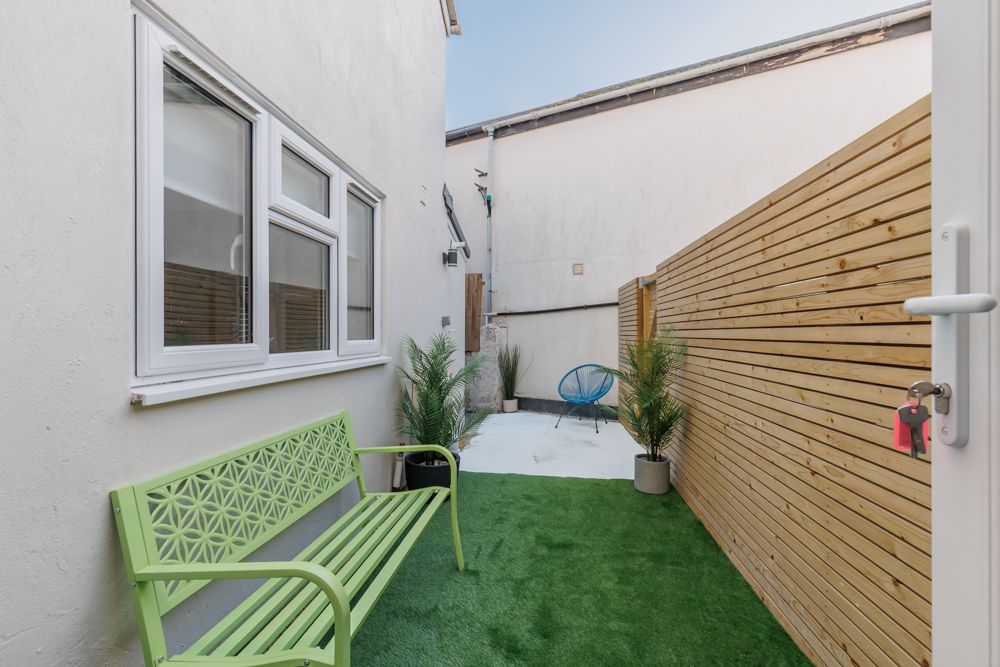Alleyway outside property with fence and grass